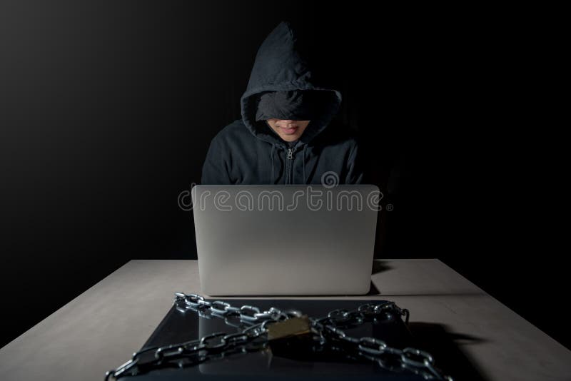 Pirata informatico maschio dietro il computer portatile, concetto cyber di attacco immagini stock Pirata informatico maschio dietro il computer portatile, concetto cyber di attacco immagini stock