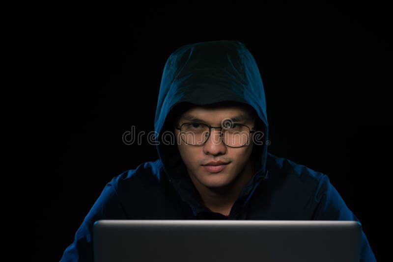 Pirate informatique asiatique entaillant le réseau informatique avec l'ordinateur portable dans l'obscurité Cyber photos libres de droits Pirate informatique asiatique entaillant le réseau informatique avec l'ordinateur portable dans l'obscurité Cyber photos libres de droits
