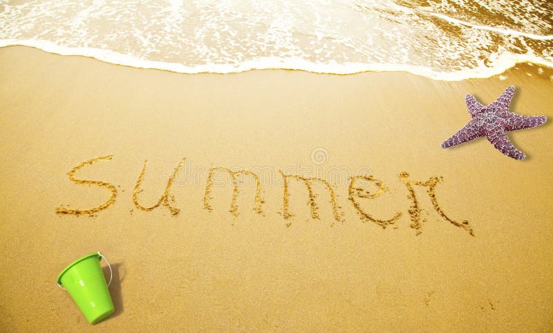 Summer Written in Sand on Beach with a sea star and a toy bucket. Summer Written in Sand on Beach with a sea star and a toy bucket