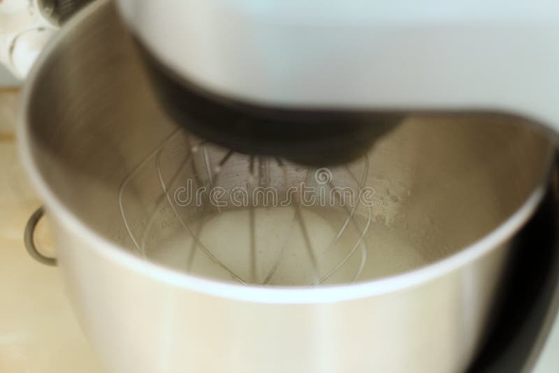 Piska? ggvitor i yrkesm? ssig k? kblandare i en restaurang Närbilden piskade viter och socker i en planetarisk blandare för metall royaltyfri fotografi
