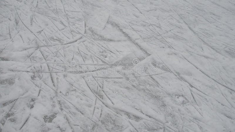 Pista di pattinaggio su ghiaccio e gambe con pattini. sport invernale. divertimento sul ghiaccio. ghiaccio con neve. pattini ai pi