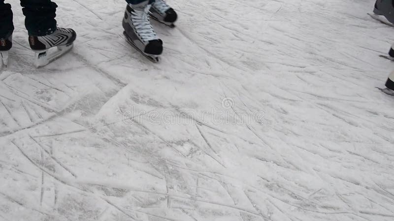 Pista di pattinaggio su ghiaccio e gambe con pattini. sport invernale. divertimento sul ghiaccio. ghiaccio con neve. pattini ai pi