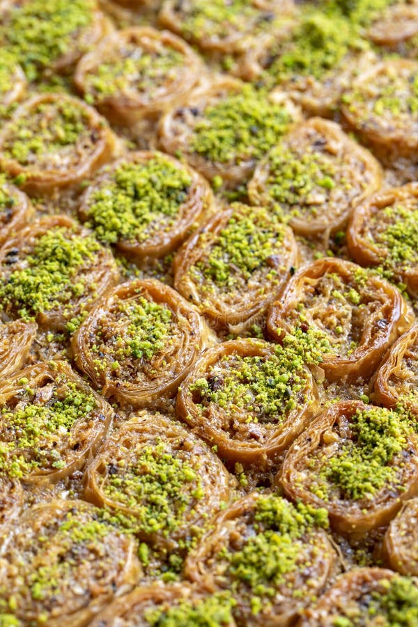 Pistachio baklava dessert on a white background. Turkish sweet dessert concept. Sherbet sweet Mediterranean bakery. close up. selective focus. Vertical view. Story format. Local name fıstıklı saray sarması baklava