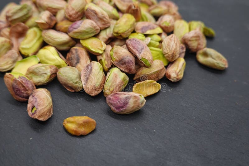 Pistachios resting on dark background creating delicious snack royalty free stock image