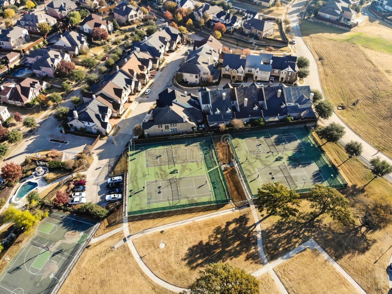 Pistas de tenis residenciales de la visión superior con los jugadores en la mañana del otoño en Tejas del norte, América imagen de archivo libre de regalías Pistas de tenis residenciales de la visión superior con los jugadores en la mañana del otoño en Tejas del norte, América imagen de archivo libre de regalías
