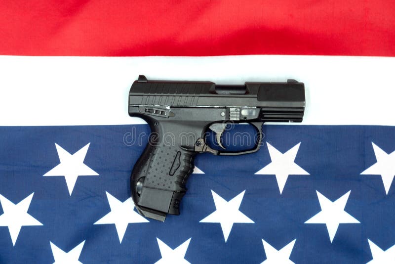 Pistol, american flag flat lay on gray background. United States Gun Laws - Guns and weapons