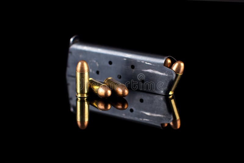 Pistol magazine with ammunition on black stock photo
