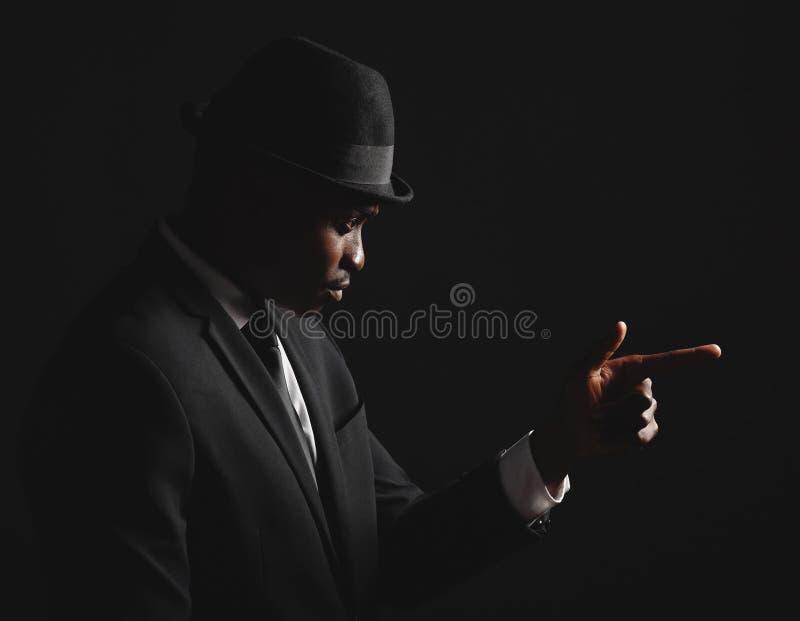 Pistola a dito nero e tuta di moda in nero per agenti eleganti e boss del crimine. uomo fotografia stock libera da diritti
