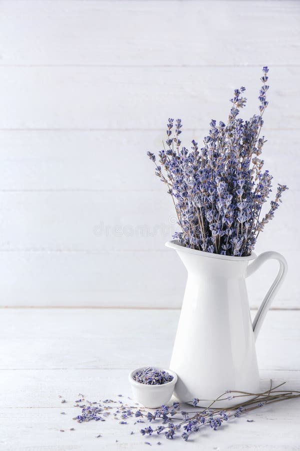 Pitcher mit schönen Lavendelblumen auf weißem Holztisch lizenzfreie stockfotografie Pitcher mit schönen Lavendelblumen auf weißem Holztisch lizenzfreie stockfotografie