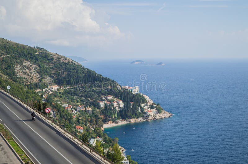 Pittoresk kust- väg med motorcykeln och sikt på Dubrovnik fotografering för bildbyråer Pittoresk kust- väg med motorcykeln och sikt på Dubrovnik fotografering för bildbyråer