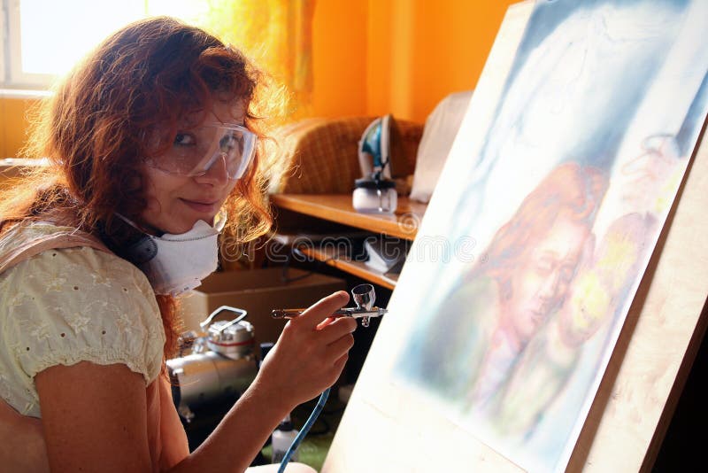 Pittura della giovane donna con l'attrezzatura dell'aerografo fotografia stock libera da diritti Pittura della giovane donna con l'attrezzatura dell'aerografo fotografia stock libera da diritti