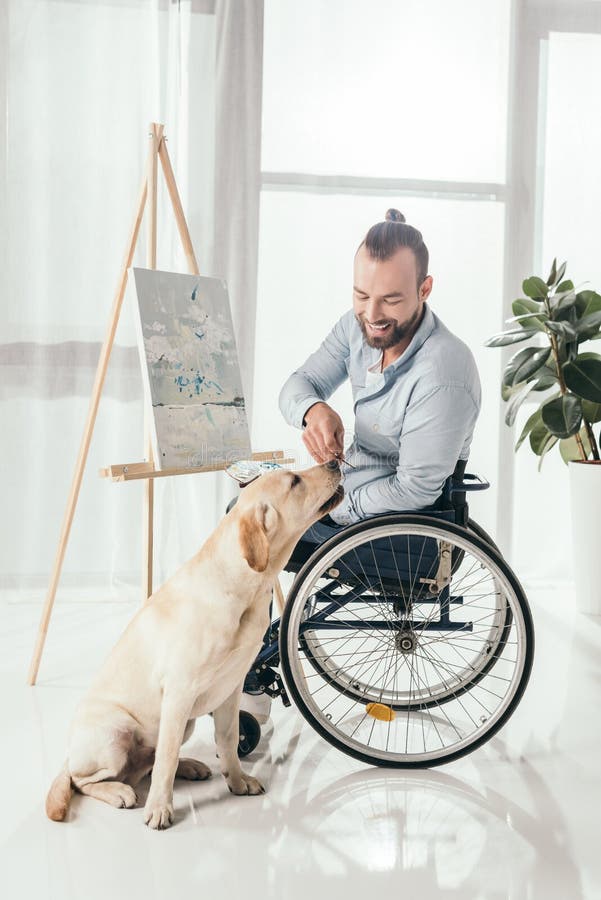 Pittura disabile dell'uomo e cane di coccole fotografia stock libera da diritti Pittura disabile dell'uomo e cane di coccole fotografia stock libera da diritti