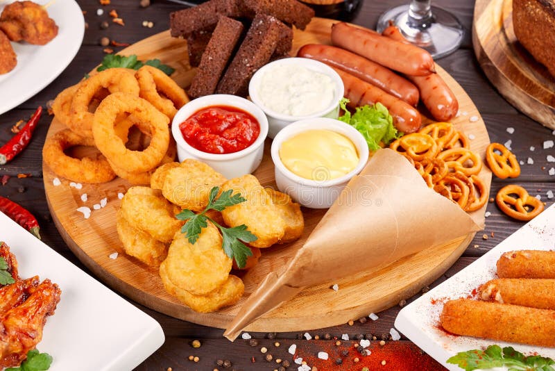 Piwnych przekąsek zamknięty up Piec na grillu kiełbasy, bryłki z cebulkowymi pierścionkami i kumberlandy, obrazy stock Piwnych przekąsek zamknięty up Piec na grillu kiełbasy, bryłki z cebulkowymi pierścionkami i kumberlandy, obrazy stock