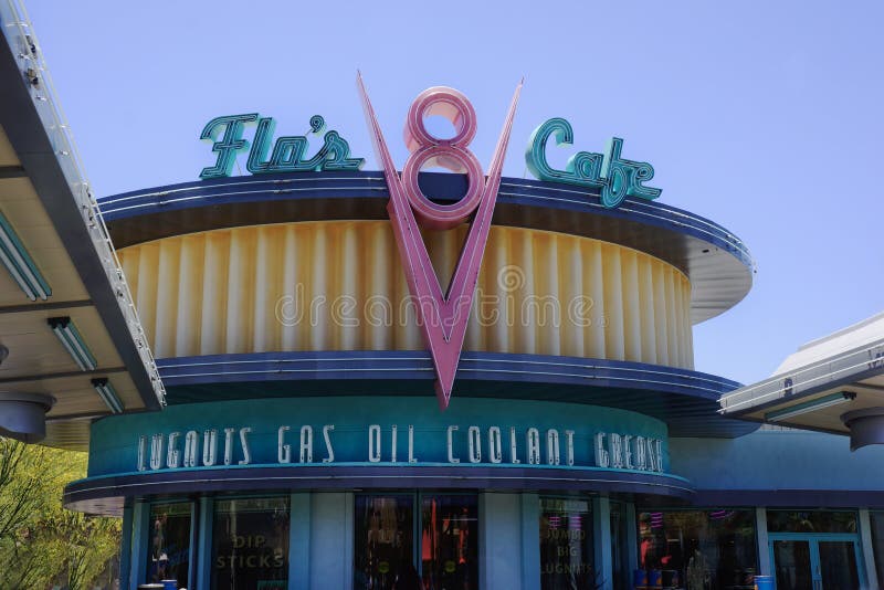 Pixar animated film called Cars.. In Cars, Flo`s V8 Cafe first appeared when Lightning McQueen was being chased by Sheriff. The cafe in Carsland section of California Adventure park is near Radiator Springs. Nearby is Walt Disney`s Disneyland amusement park. Anaheim, California. Pixar animated film called Cars.. In Cars, Flo`s V8 Cafe first appeared when Lightning McQueen was being chased by Sheriff. The cafe in Carsland section of California Adventure park is near Radiator Springs. Nearby is Walt Disney`s Disneyland amusement park. Anaheim, California