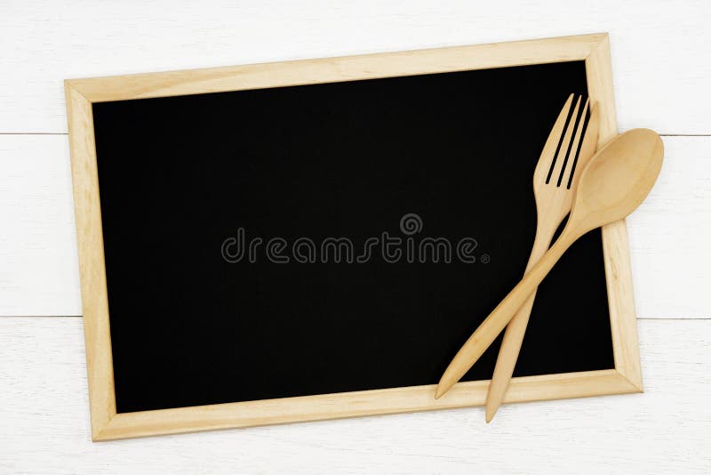 Pizarra en blanco con la cuchara de madera y bifurcación en el fondo de madera blanco del tablón fotografía de archivo libre de regalías Pizarra en blanco con la cuchara de madera y bifurcación en el fondo de madera blanco del tablón fotografía de archivo libre de regalías