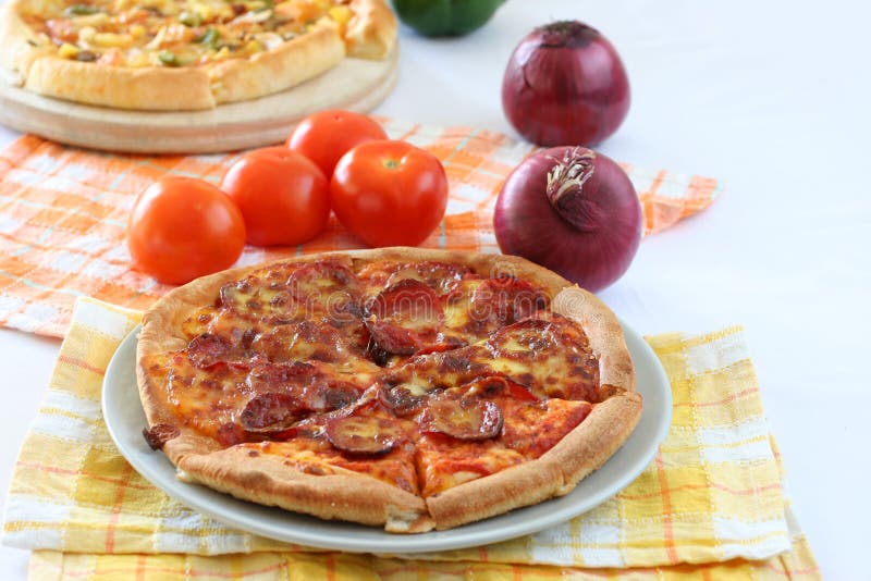 Pepperoni pizza in ceramic plate and yellow thatched table matt