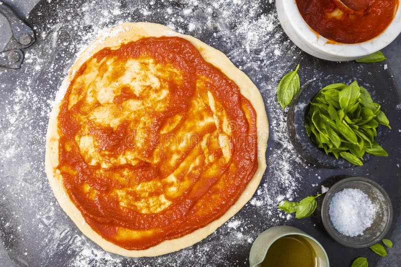 Pizza Base Being Put on Pizza Dough Laid Out on Kitchen Bench Stock ...