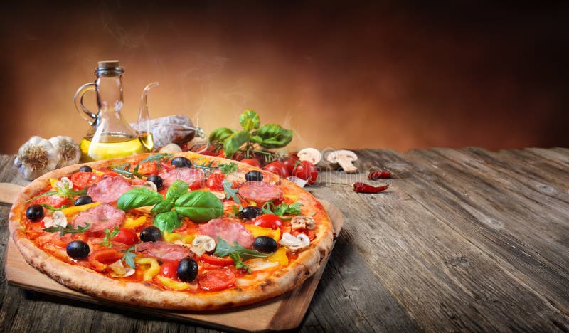 Pizza caliente servida en la tabla vieja fotografía de archivo Pizza caliente servida en la tabla vieja fotografía de archivo