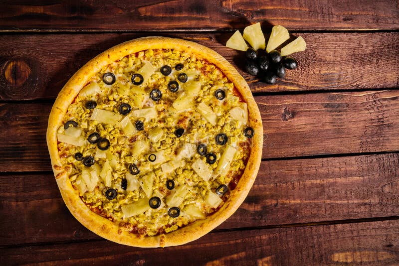 Pizza with chicken and pineapple on a wooden table stock photography Pizza with chicken and pineapple on a wooden table stock photography