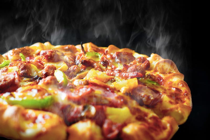 Pizza com bacon e pepperoni do presunto do queijo no fundo preto isolado com fumo cozinhando quente Alimento e conceito do cozime foto de stock royalty free Pizza com bacon e pepperoni do presunto do queijo no fundo preto isolado com fumo cozinhando quente Alimento e conceito do cozime foto de stock royalty free