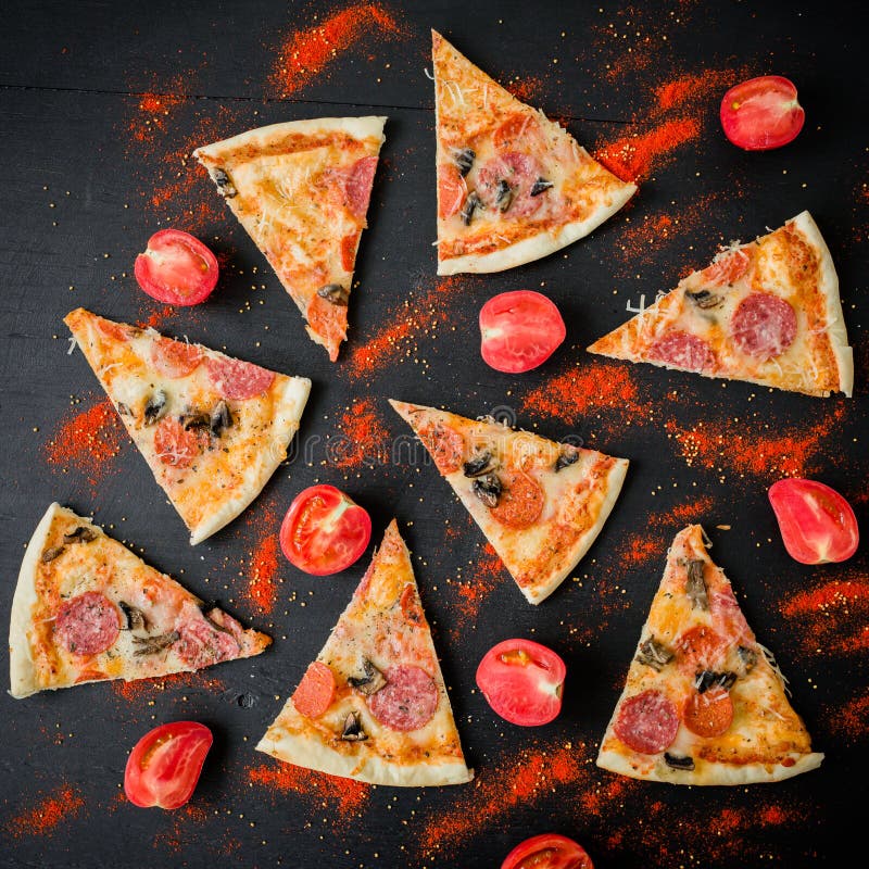 Pizza com os ingredientes na tabela escura Teste padrão de fatias e de tomate da pizza Configuração lisa, vista superior
