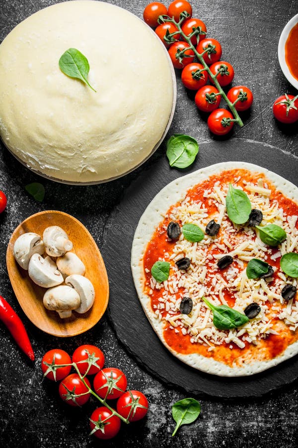 Pizza cruda Pasta con passata di pomodoro, i funghi, le olive ed il peperoncino fotografia stock