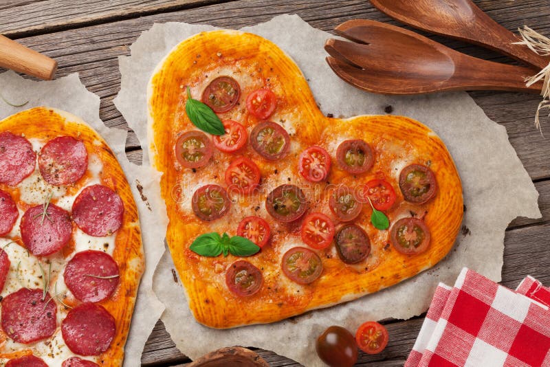 Pizza dada forma coração com tomates e mussarela imagens de stock royalty free Pizza dada forma coração com tomates e mussarela imagens de stock royalty free