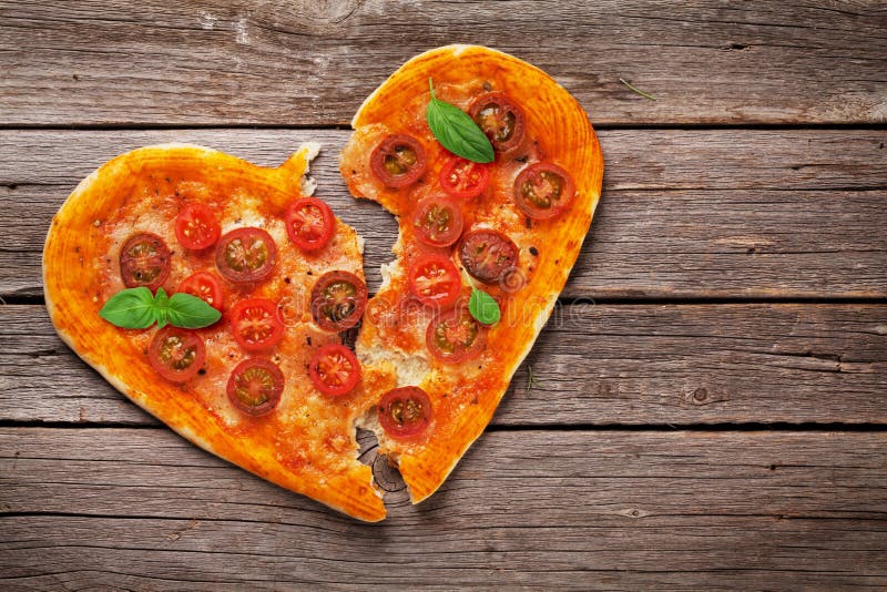 Pizza dada forma coração com tomates e mussarela fotos de stock Pizza dada forma coração com tomates e mussarela fotos de stock