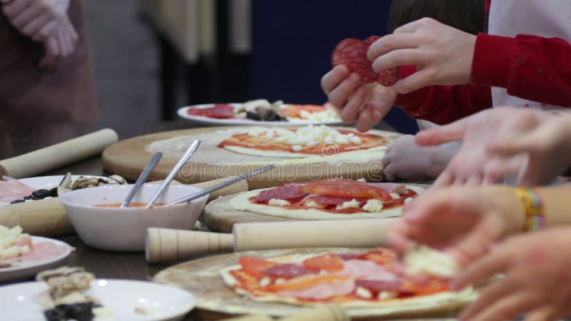 Pizza de cocción infantil. clase magistral del chef en un restaurante clausurado de niños se deshace de la masa almacen de video