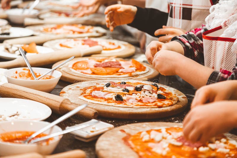 Pizza de cocción infantil. clase magistral del chef en un restaurante clausurado de niños se deshace de la masa fotos de archivo libres de regalías