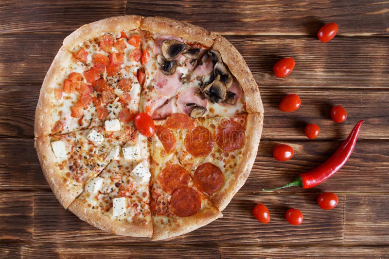 Pizza deliciosa com pepperoni, salame da quatro-parte, pimenta de pimentão vermelho, presunto, cogumelos, queijo, mentiras dos to fotografia de stock Pizza deliciosa com pepperoni, salame da quatro-parte, pimenta de pimentão vermelho, presunto, cogumelos, queijo, mentiras dos to fotografia de stock