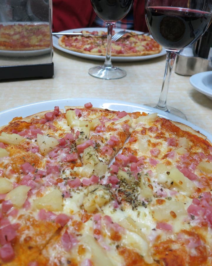 Pizza deliciosa de Hawaian e um vidro do vinho tinto fotos de stock royalty free Pizza deliciosa de Hawaian e um vidro do vinho tinto fotos de stock royalty free