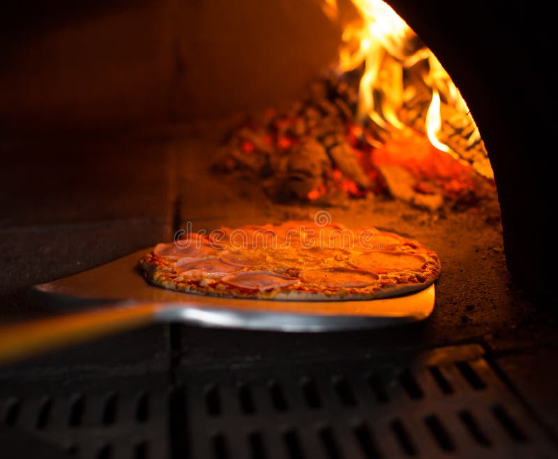 Pizza, die vom Ofen erhält lizenzfreie stockfotos Pizza, die vom Ofen erhält lizenzfreie stockfotos