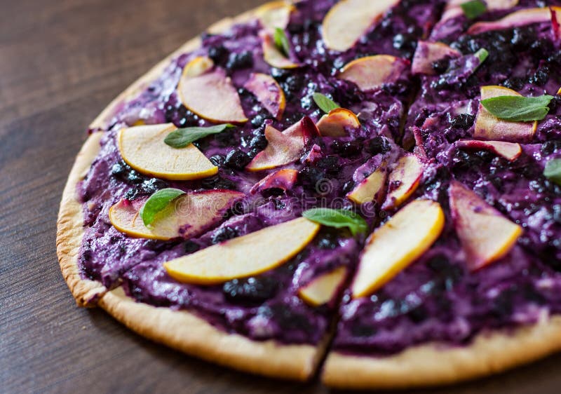 Pizza doce com queijo da ricota, mirtilo e maçã das fatias pizza da sobremesa em um de madeira imagem de stock Pizza doce com queijo da ricota, mirtilo e maçã das fatias pizza da sobremesa em um de madeira imagem de stock