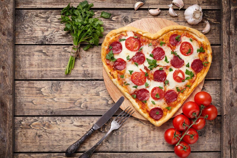 Pizza a forma di del cuore di giorno di biglietti di S. Valentino con le merguez