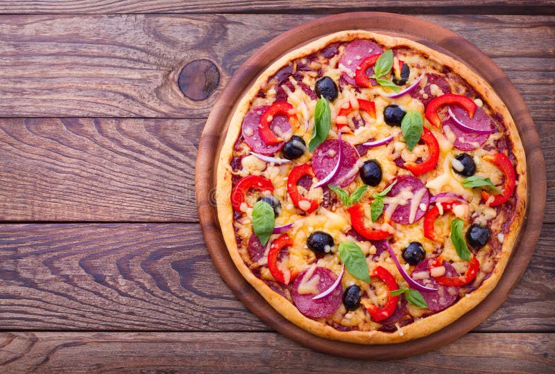 Pizza fresca deliciosa servida en la tabla de madera. imagen de archivo Pizza fresca deliciosa servida en la tabla de madera. imagen de archivo