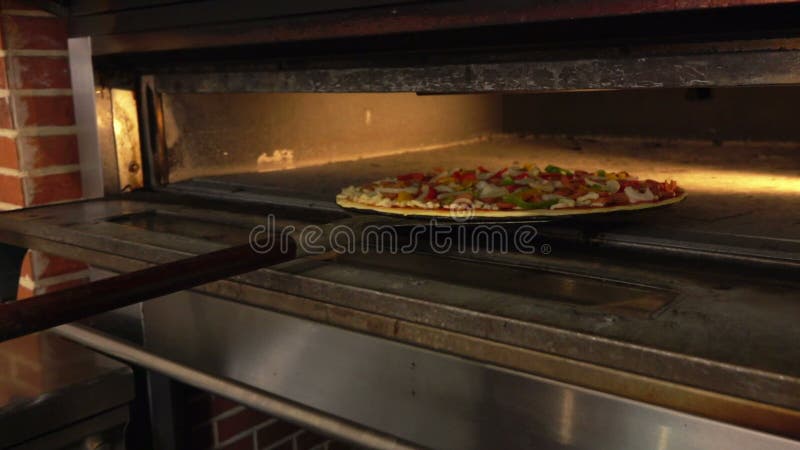 Pizza förläggas i ugnen