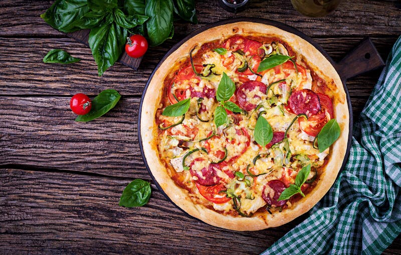 Pizza italiana com galinha, salame, abobrinha, tomates e ervas imagem de stock royalty free Pizza italiana com galinha, salame, abobrinha, tomates e ervas imagem de stock royalty free