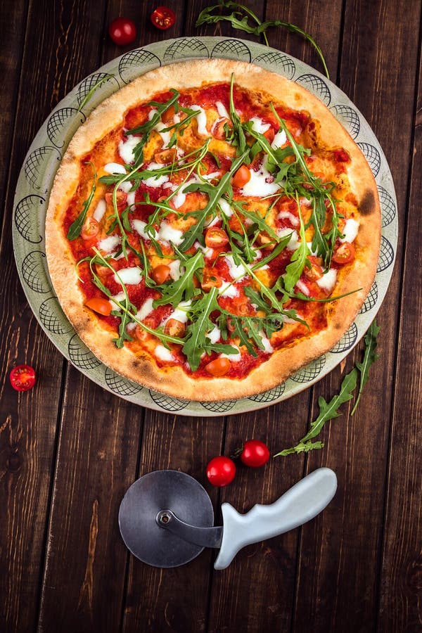 Pizza Margherita de vue supérieure avec du mozzarella de Buffalo, les tomates et le basilic frais Le coupeur de pizza se trouve s images libres de droits Pizza Margherita de vue supérieure avec du mozzarella de Buffalo, les tomates et le basilic frais Le coupeur de pizza se trouve s images libres de droits