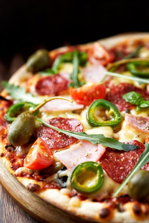 Pizza met salami en ham stock foto. Afbeelding bestaande uit