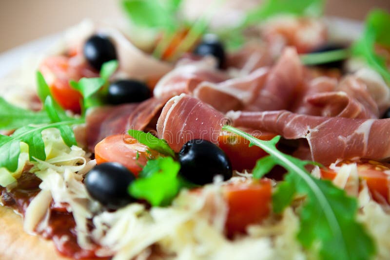 Pizza mit prosciutto und Oliven lizenzfreies stockfoto Pizza mit prosciutto und Oliven lizenzfreies stockfoto
