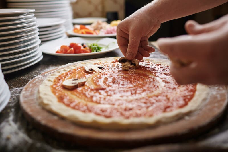 Chef cooking pizza with mushrooms