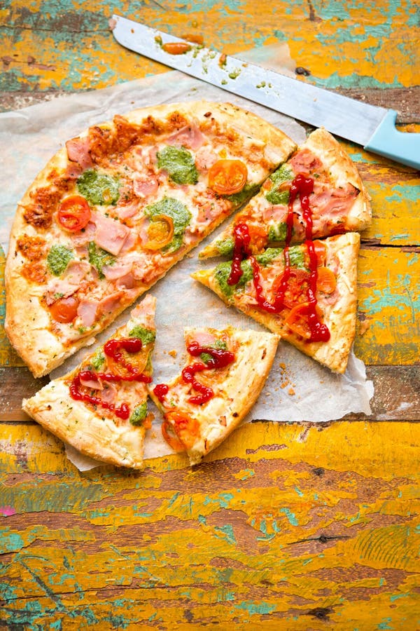 Pizza with Parma Ham, Cheese, Green Pesto and Tomatoes Stock Photo