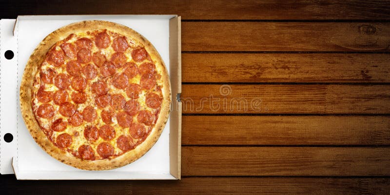 Pizza pepperoni in delivery box top view for flyer. Hot pizza salami and mozzarella cheese on wooden background for