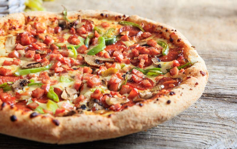 Pizza på en trätabell royaltyfri bild Pizza på en trätabell royaltyfri bild