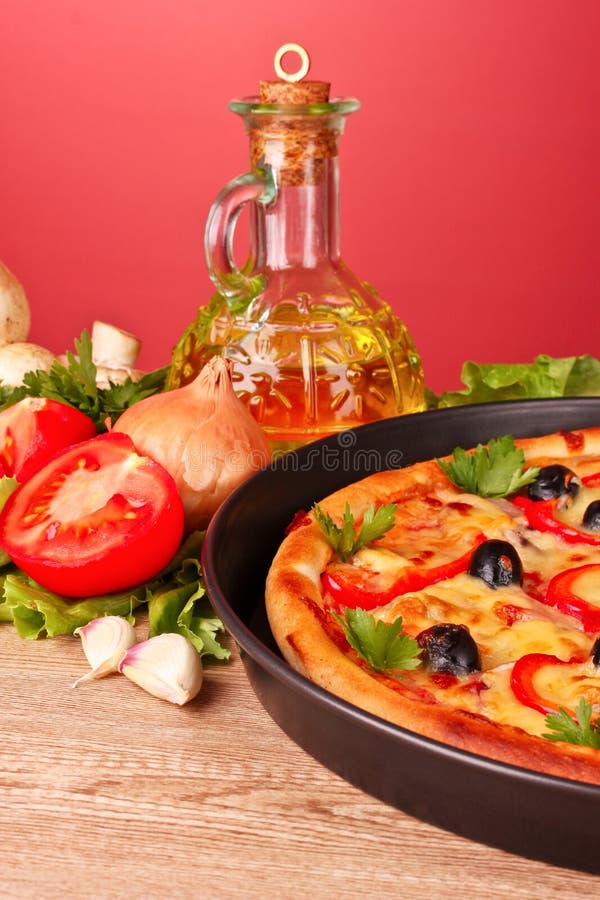 Pizza and vegetables on a red royalty free stock images