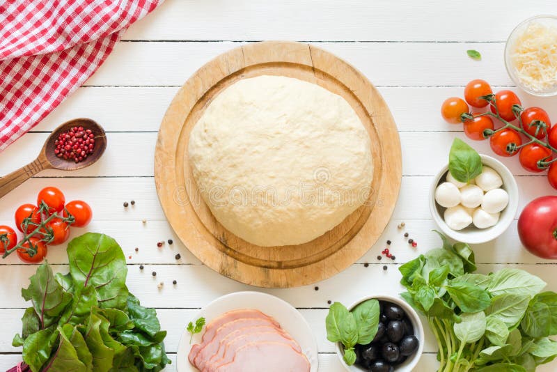 Pizzadeeg en ingrediënten voor pizza op witte lijst stock afbeeldingen Pizzadeeg en ingrediënten voor pizza op witte lijst stock afbeeldingen