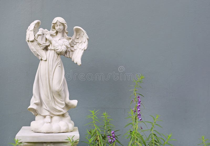 Piękna anioł statua przeciw szarości ściany tłu zdjęcie royalty free Piękna anioł statua przeciw szarości ściany tłu zdjęcie royalty free