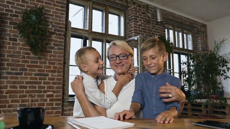 Piękni środkowi rok kobiety siedzi przy drewnianym biurkiem pracuje z papierowymi dokumentami w szkłach podczas gdy jej uroczy wn zbiory wideo