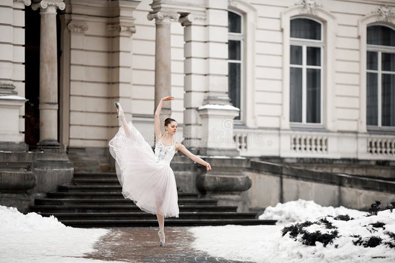 Piękny balerina taniec obok budynku na śnieżnym tle zdjęcia stock Piękny balerina taniec obok budynku na śnieżnym tle zdjęcia stock
